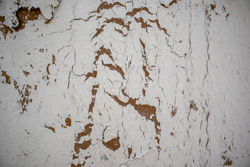Abstract background texture of white wall with peeling paint, plaster. The dilapidated surface...