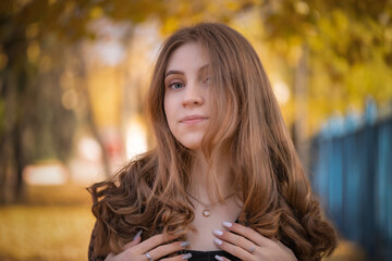 Close-up portrait of a young beautiful girl in an autumn park.