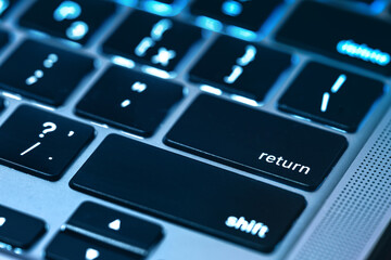 Return key on modern laptop keypad close-up.