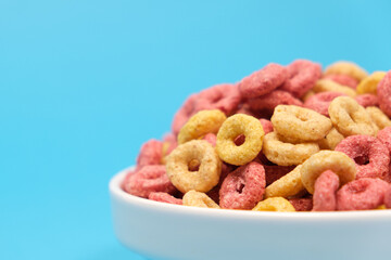 Quick cereal breakfast in the form of rings on a plate on a blue background