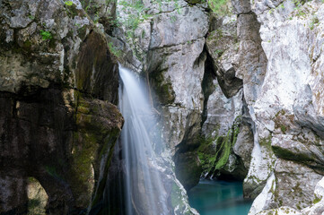 Fototapeta na wymiar Blurred image of beautiful waterfall in big gorge of river soca