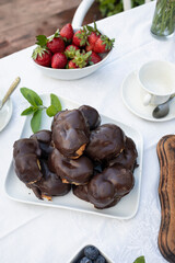 Delicious snack in the garden with fruit and puff pastries with chocolate. Sweets for tea or coffee time in the garden. Typical sweet from Morata de Tajuña (Spain)