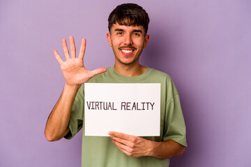 Young hispanic man holding virtual reality placard isolated on purple background smiling cheerful showing number five with fingers.