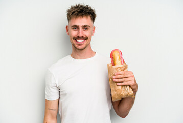 Young caucasian man holding a sandwich isolated on white background happy, smiling and cheerful.