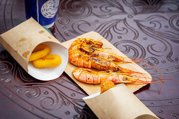 Grilled shrimps and squid rings on table close-up. Barbecue grill outdoors, summer picnic