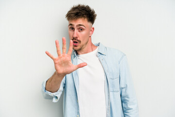Young caucasian man isolated on white background being shocked due to an imminent danger