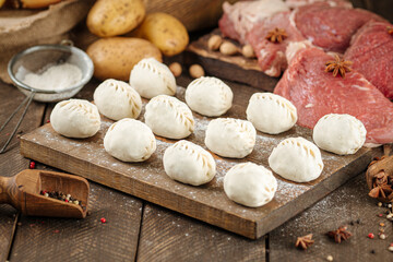 Semi finished manti dumplings on wooden board