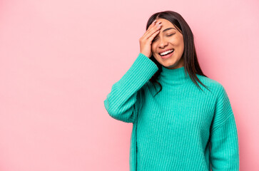 Young hispanic woman isolated on pink background laughing happy, carefree, natural emotion.