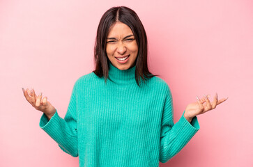 Young hispanic woman isolated on pink background screaming with rage.