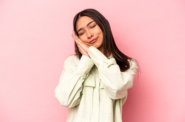 Young hispanic woman isolated on pink background yawning showing a tired gesture covering mouth with hand.
