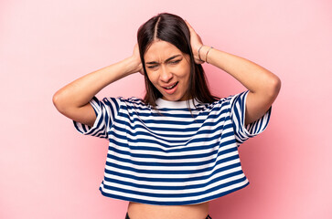 Young hispanic woman isolated on pink background screaming, very excited, passionate, satisfied with something.