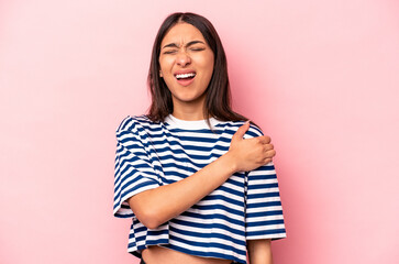 Young hispanic woman isolated on pink background having a shoulder pain.
