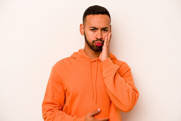 Young hispanic man isolated on white background blows cheeks, has tired expression. Facial expression concept.