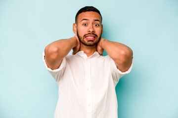 Young hispanic man isolated on blue background screaming with rage.