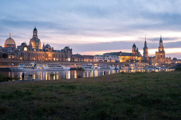 Fototapeta na wymiar View from the Königsufer to the skyline from the oldtown from the city Dresden with the Frauenkirche at sunset.