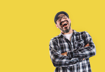 Man laughing very hard isolated on yellow background. Good mood, jokes and happiness - obrazy, fototapety, plakaty
