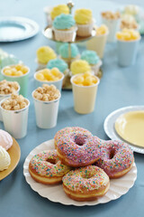 High angle view of candy bar with glazed baked donuts, cakes, sweets on table preparing for party