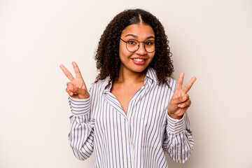 Young African American woman isolated on white background showing victory sign and smiling broadly.