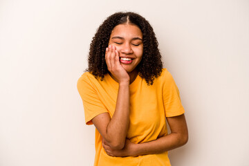 Young African American woman isolated on white background laughs happily and has fun keeping hands...