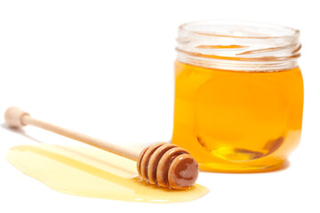 Fototapeta na wymiar Honey dripping from honey dipper in glass jar. Healthy food concept