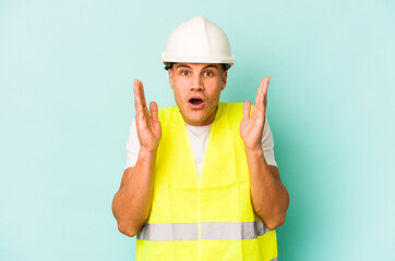 Young laborer caucasian man isolated on blue background surprised and shocked.