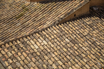 View of several old roofs typical of Spain with old tiles and aged by time creating a texture of geometric lines