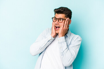 Young caucasian man isolated on blue background scared and afraid.