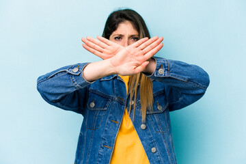 Young caucasian woman isolated on blue background doing a denial gesture