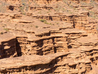 Red tales from clay. Issyk-Kul region in Kyrgyzstan. Beautiful mountain landscape. Tourism and travel.