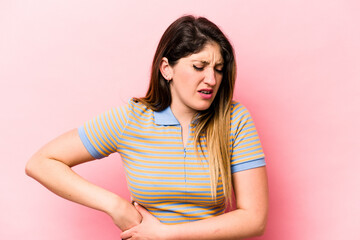 Young caucasian woman isolated on pink background having a liver pain, stomach ache.