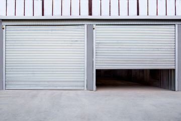 2 gray iron shutter door? of garage and industrial building warehouse exterior facade with grey concrete road, front view on closing gate nobody.