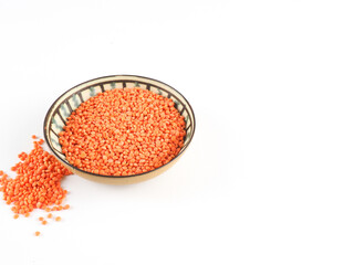 Red lentils in a green bowl on a green background. Red lentils macro. 