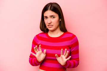 Young caucasian woman isolated on pink background rejecting someone showing a gesture of disgust.