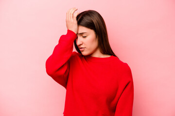 Young caucasian woman isolated on pink background forgetting something, slapping forehead with palm and closing eyes.