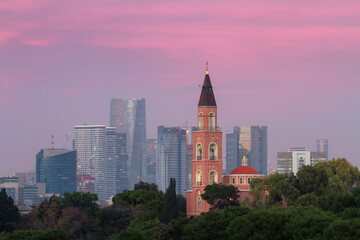 Fototapeta na wymiar Tel Aviv: Russian Orthodox church and modern skyscrapers at pink sunset