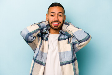 Young hispanic man isolated on blue background screaming with rage.