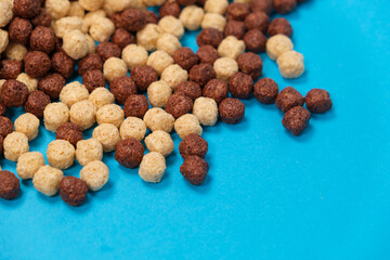 Breakfast cereal - corn and wheat balls with cocoa on a blue background.