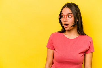 Fototapeta premium Young hispanic woman isolated on yellow background being shocked because of something she has seen.