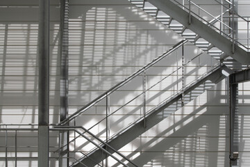 Close-up and detail shots of a metal staircase set in front of a light-colored wall. The stairs...