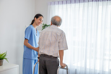 Asian young nurse take care a senior with a walker in a retired home service.