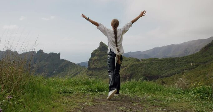 Masca valley,Tenerife. Beautiful young woman tourist raising her arms enjoying the landscape view
