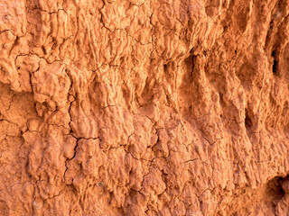 Texture of red clay. Natural natural patterns. Dry red background closeup.