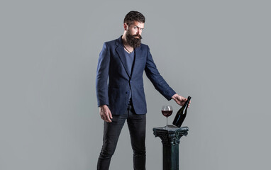 Red wine in bottle, wine glass. Red wine in a glass. Sommelier man, degustator, winery. Man holding...