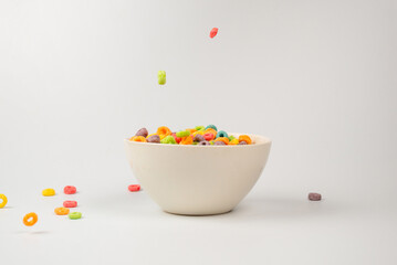 Colorful cereal box for morning breakfast. Corn flakes falling to the white bowl. Motion.