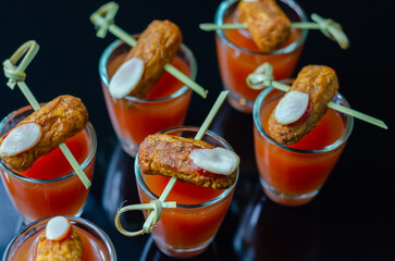 Bloody Mary cocktails in the shots drink served with Halloween bloody fingers, pork cocktail sausages decorated with flaked almonds
