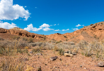 Red tales from clay. Issyk-Kul region in Kyrgyzstan. Beautiful mountain landscape. Tourism and...