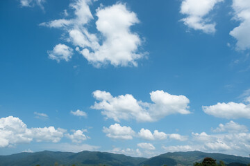 The white clouds have a strange shape and moutain.The sky and the open space have mountains below.