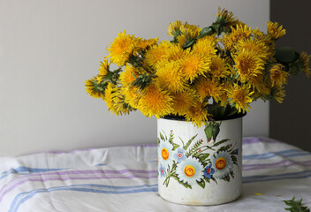 Yellow dandelions in a rustic vase