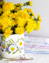Yellow dandelions in a rustic vase - 509215467