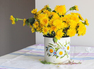 Yellow dandelions in a rustic vase - 509215473